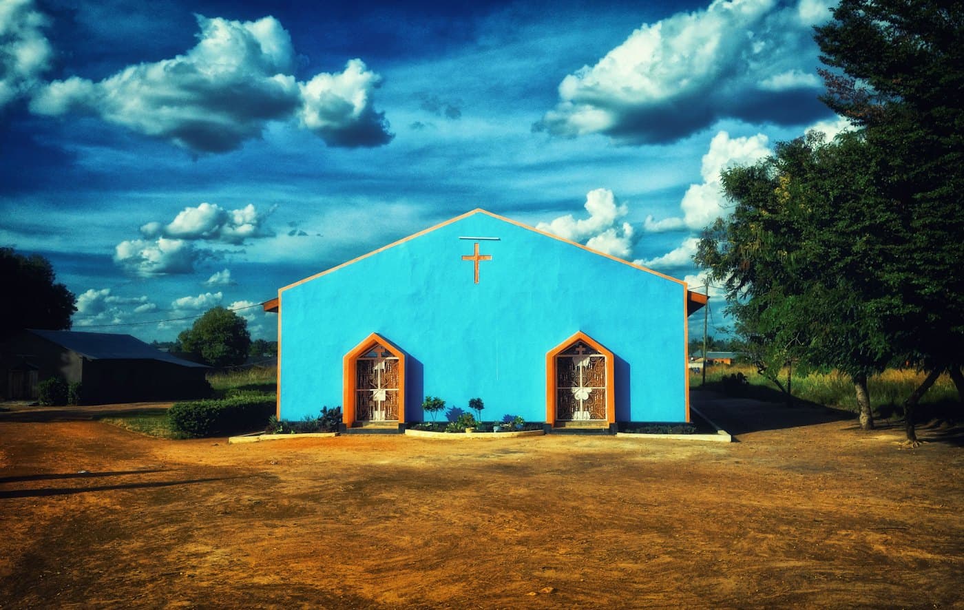 A small blue church under a wide sky