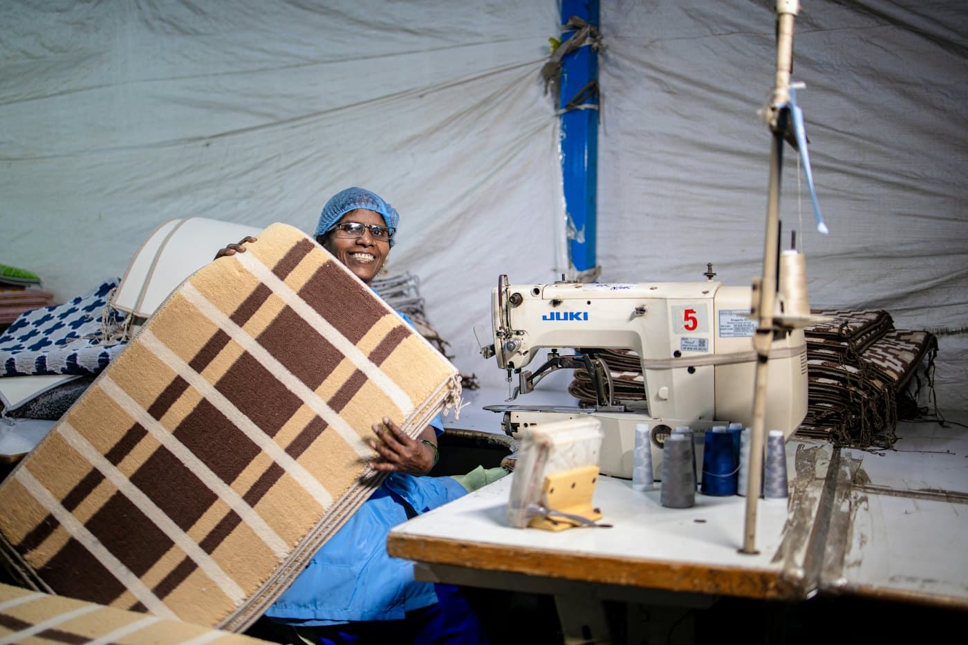 A woman sewing cushions at a workshop sewing machine