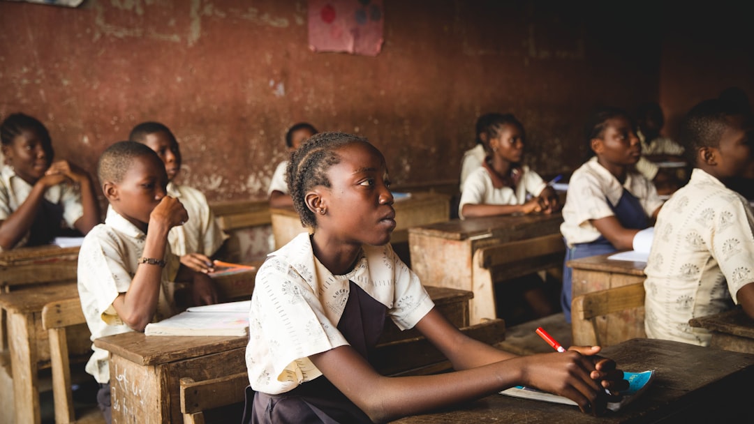 Photograph showing children sitting on chairs inside classroom — illustrating education & training programmes in Africa