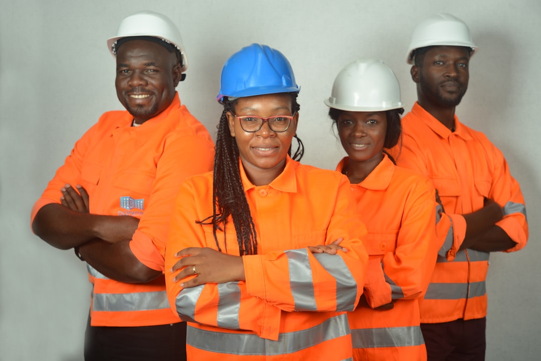Photograph showing two women and men standing in front white concrete — illustrating employment & skills programmes in Africa